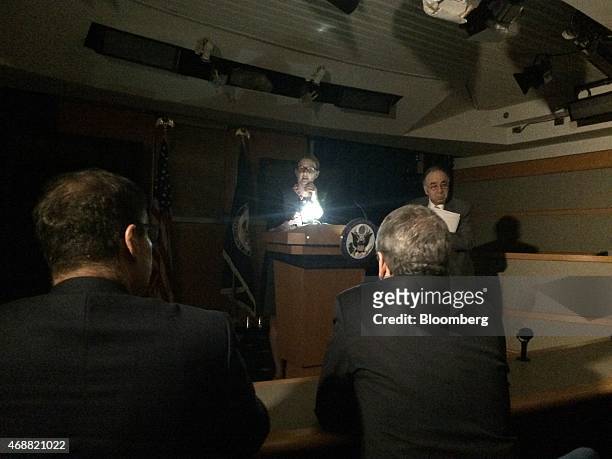 Marie Harf, a spokeswoman with the State Department, conducts the daily briefing for reporters using an iPhone to light her notes, in Washington,...