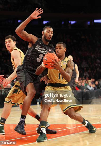 Keith Appling of the Michigan State Spartans drives to the basket against Mikael Hopkins of the Georgetown Hoyas during the game at Madison Square...