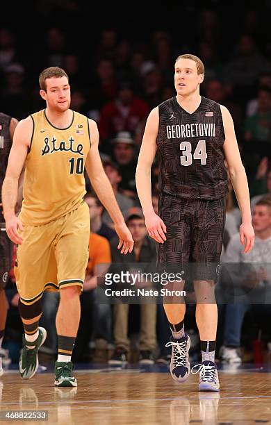 Matt Costello of the Michigan State Spartans walks on the court during a break in play next to Nate Lubick of the Georgetown Hoyas at Madison Square...