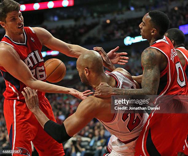 Taj Gibson of the Chicago Bulls is pulled to the ground by Jeff Teague of the Atlanta Hawks for a flagrant foul as Kyle Korver tries for the ball at...