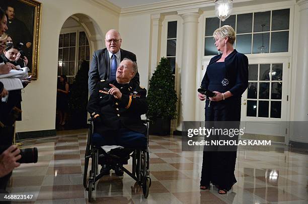 Former US senator Max Cleland and Linda Dean arrive at the White House in Washington on February 11, 2014 for the state dinner in honor of French...