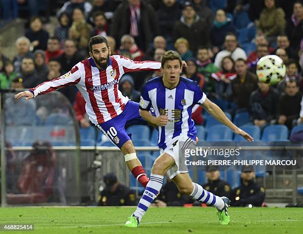 Atletico Madrid's Turkish midfielder Arda Turan kicks the ball next to Real Sociedad's midfielder Gorka Elustondo during the Spanish league football...