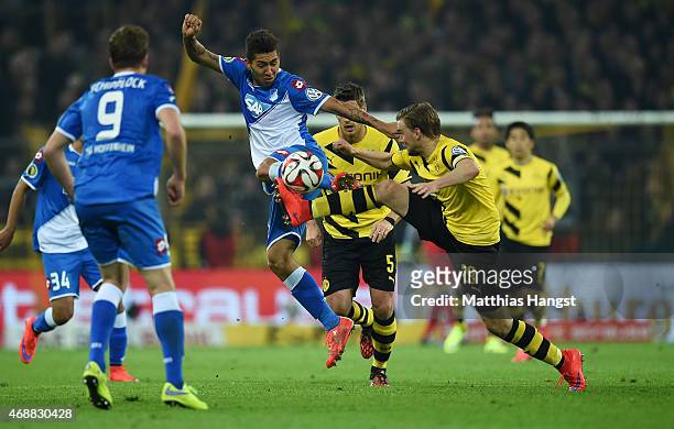 Roberto Firmino of Hoffenheim and Marcel Schmelzer of Dortmund compete for the ball during the DFB Cup Quarter Final match between Borussia Dortmund...