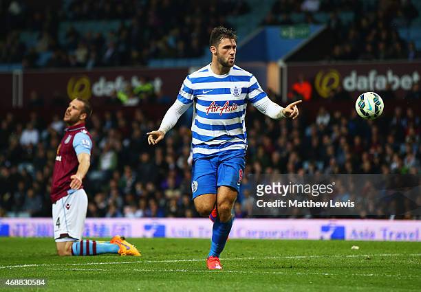Ron Vlaar of Aston Villa look dejected as Charlie Austin of QPR celebrates as he scores their third goal during the Barclays Premier League match...