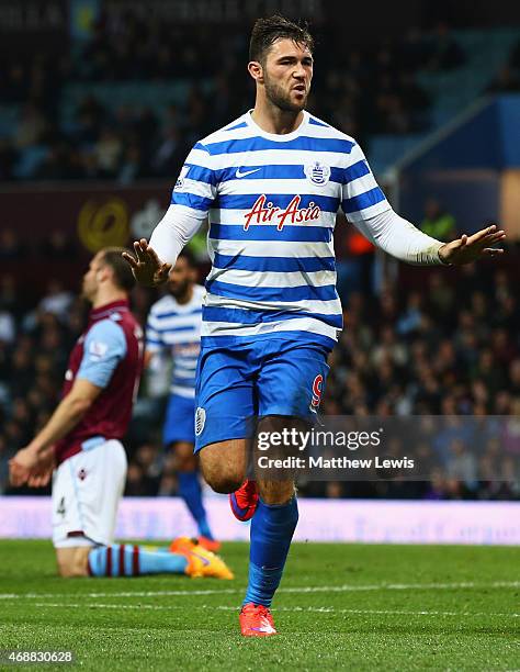 Ron Vlaar of Aston Villa look dejected as Charlie Austin of QPR celebrates as he scores their third goal during the Barclays Premier League match...