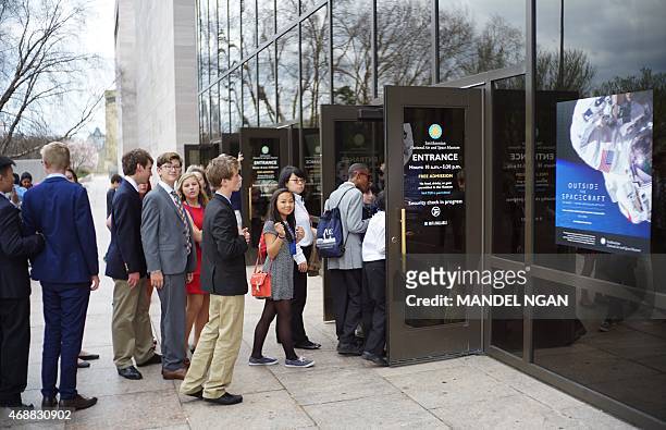 Visitors queue to enter the Smithsonian's National Air and Space Museum after it re-opened following a power outage on April 7, 2015 in Washington,...