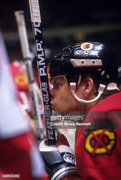 Behn Wilson of the Chicago Blackhawks kisses his stick while sitting on the bench during an NHL game against the New York Rangers on January 11, 1988...