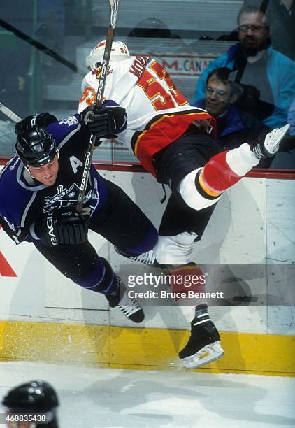 Derek Morris of the Calgary Flames checks Mattias Norstrom of the Los Angeles Kings during an NHL game circa 2000 at the Scotiabank Saddledome in...