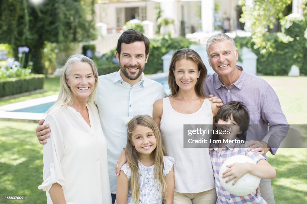 Multi-generation family smiling in backyard