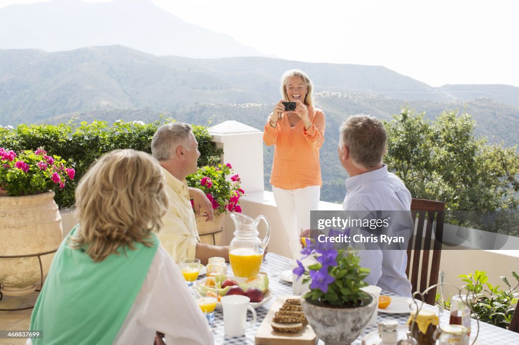 Mulher fotografar os seus amigos no terraço tabela