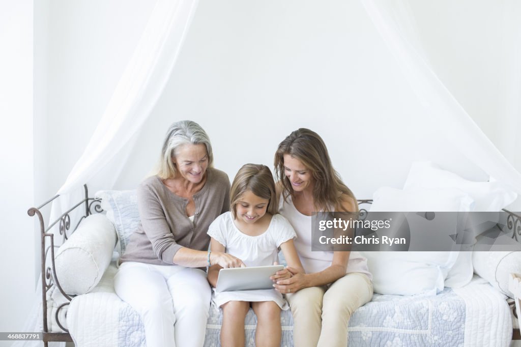 Multi geração de mulheres usando tablet digital no daybed