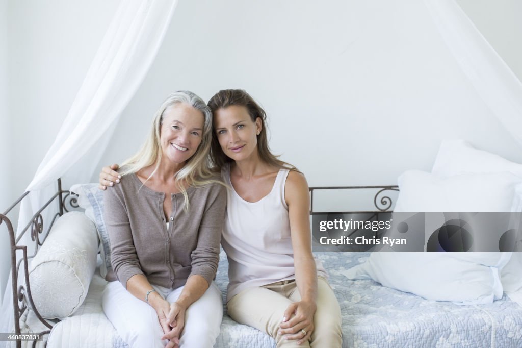 Mother and daughter smiling on daybed