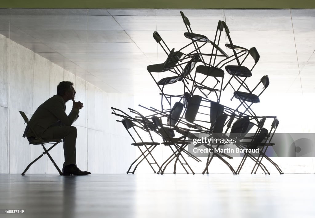 Businessman viewing office chair installation art