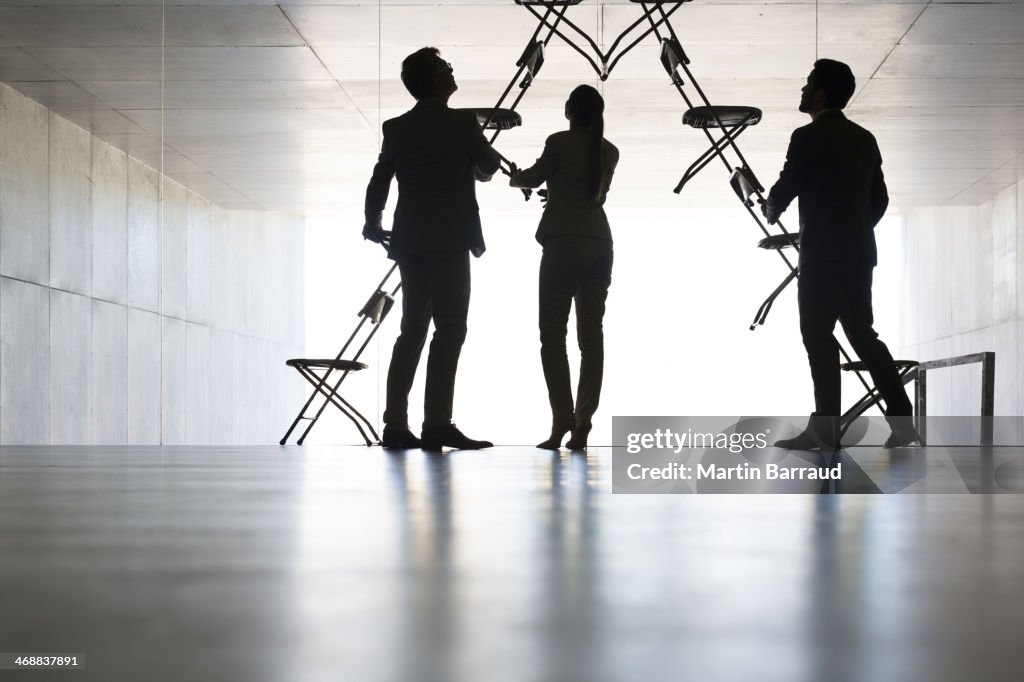 Business people making office chair installation art