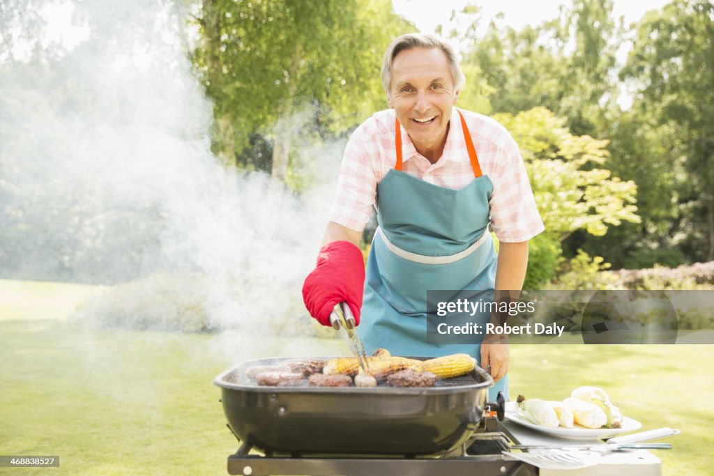 Man grilling food on barbecue in backyard