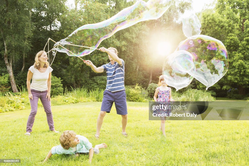 Family playing with large bubbles in backyard