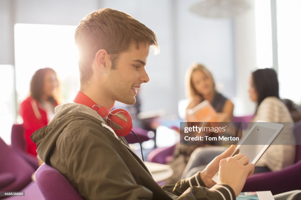 Studente universitario utilizzando digital tablet in lounge