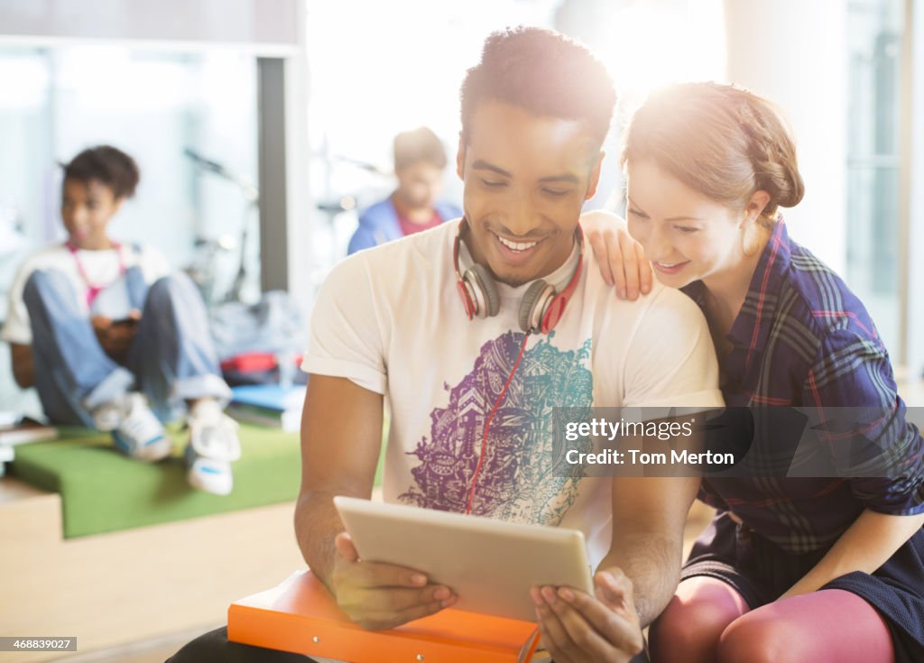 Estudantes universitários usando tablet digital no salão