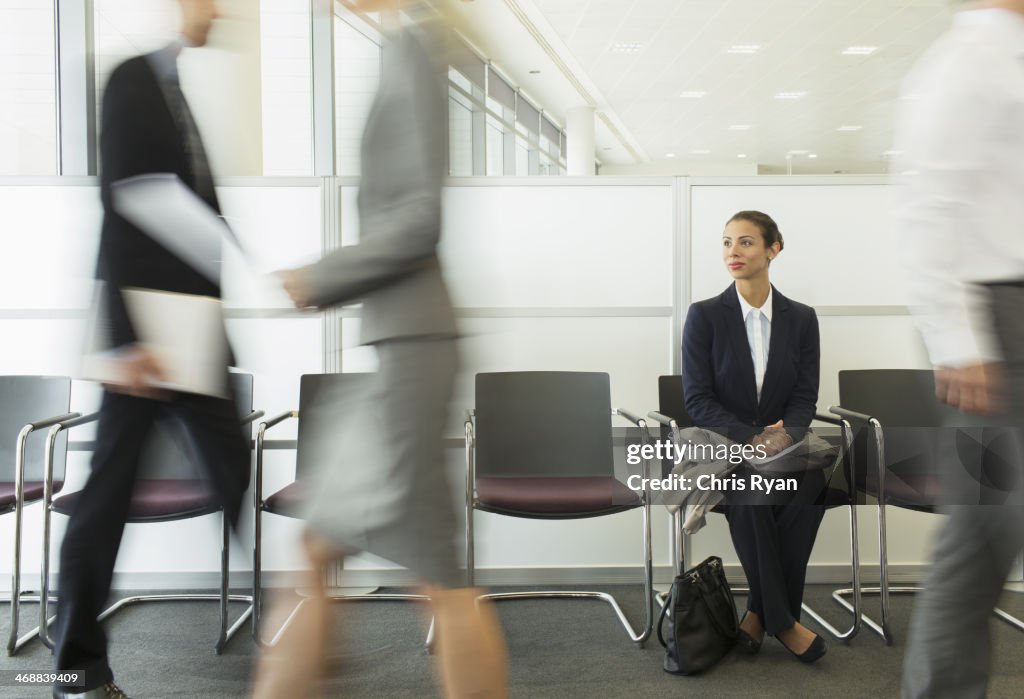 Businesswoman sitting in busy waiting area