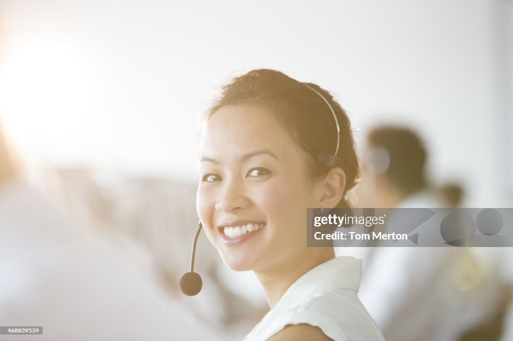 Empresaria usando auriculares en oficina
