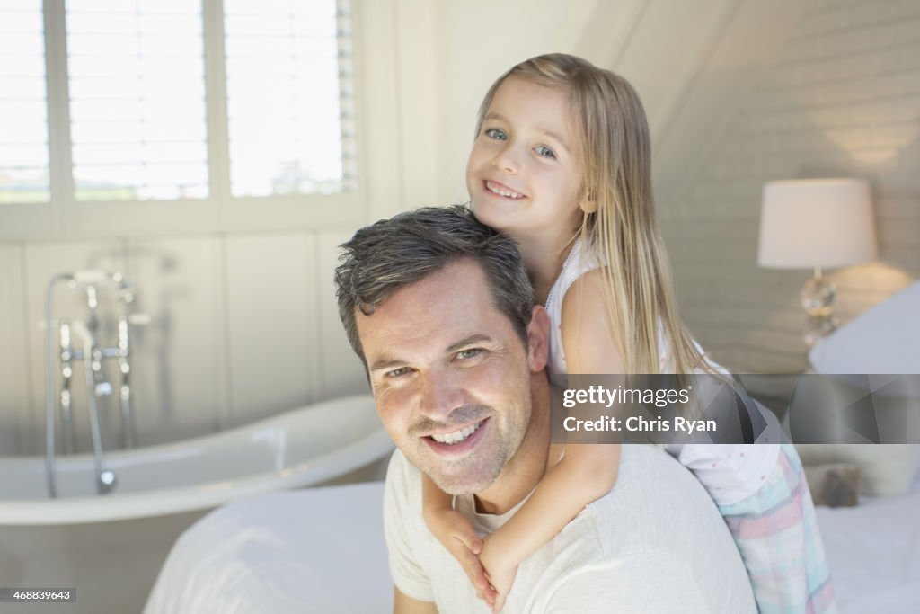 Father and daughter smiling in bedroom
