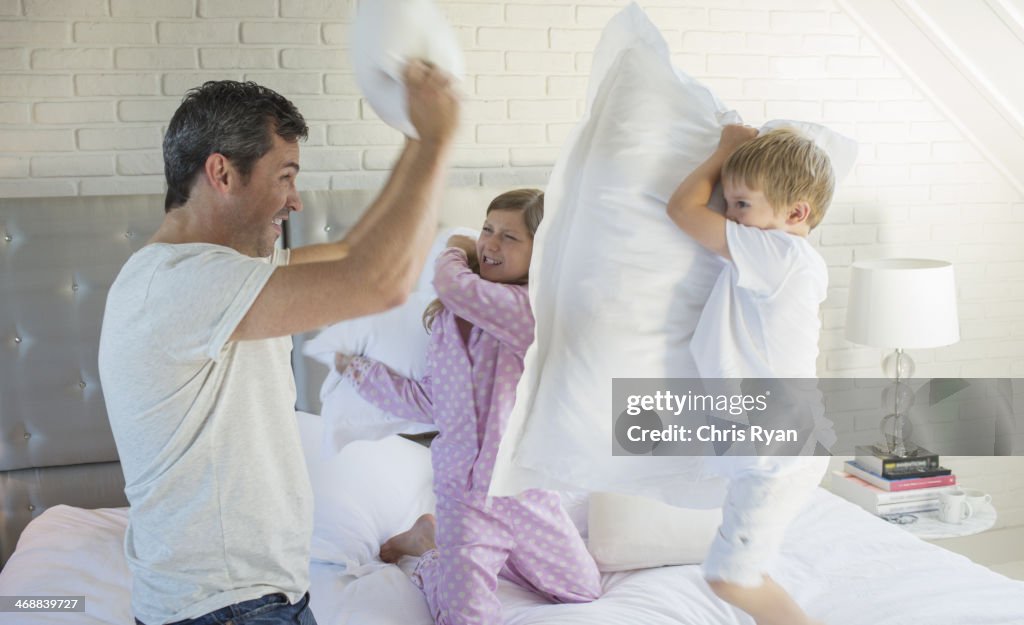 Father and children having pillow fight