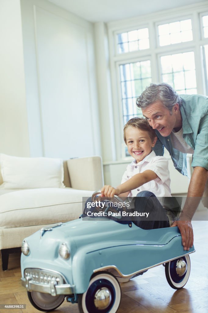 Impulsar padre hijo en coche de juguete