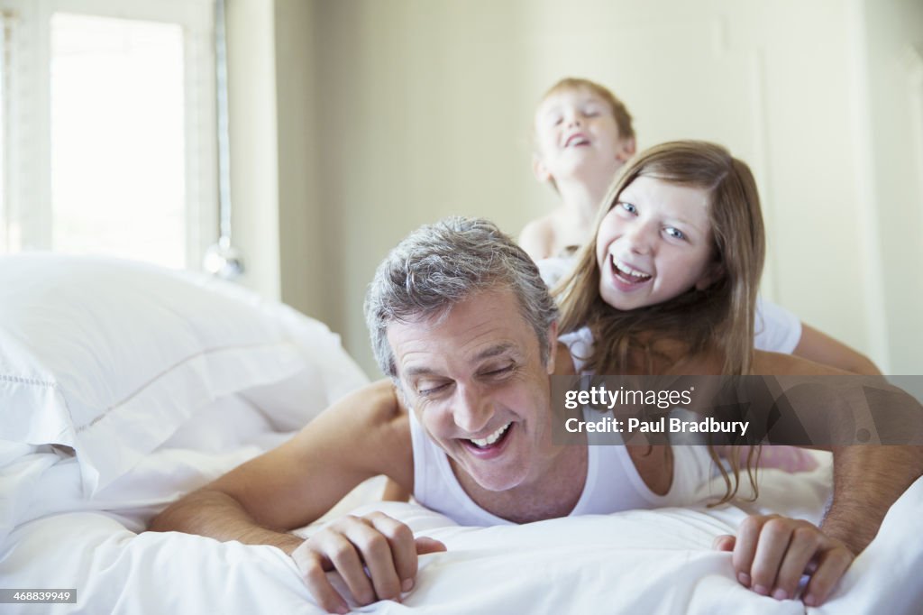 Pai e filhos Jogando na cama