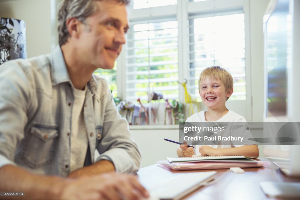 Père et fils de travail dans un bureau à domicile