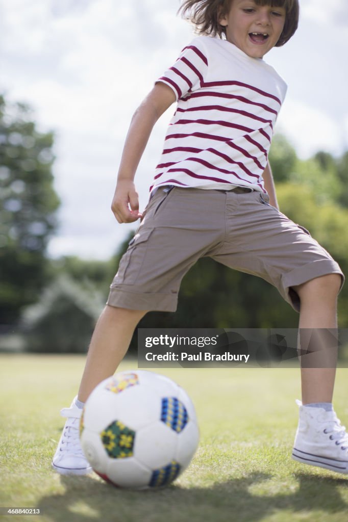 Ragazzo giocare a calcio all'aperto