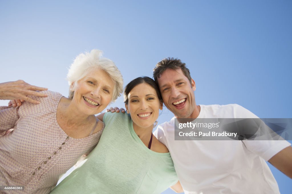 Senior donna abbracciare coppia contro il cielo blu