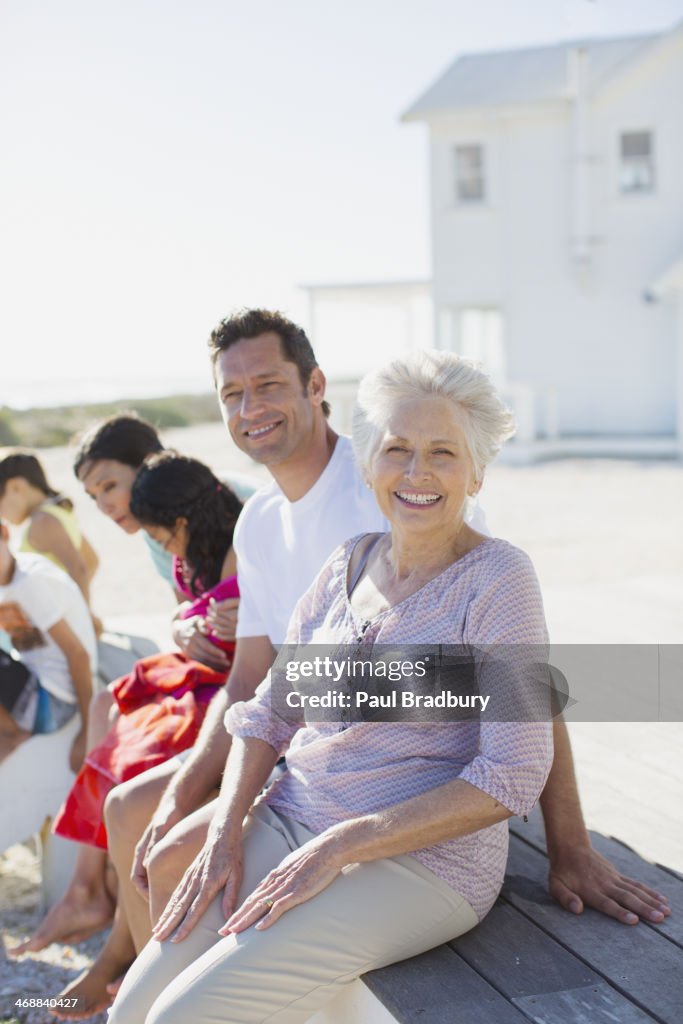 Multi-generation family smiling outside beach house