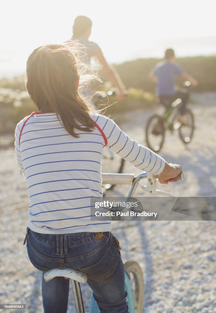 Family riding bicycles on sunny beach