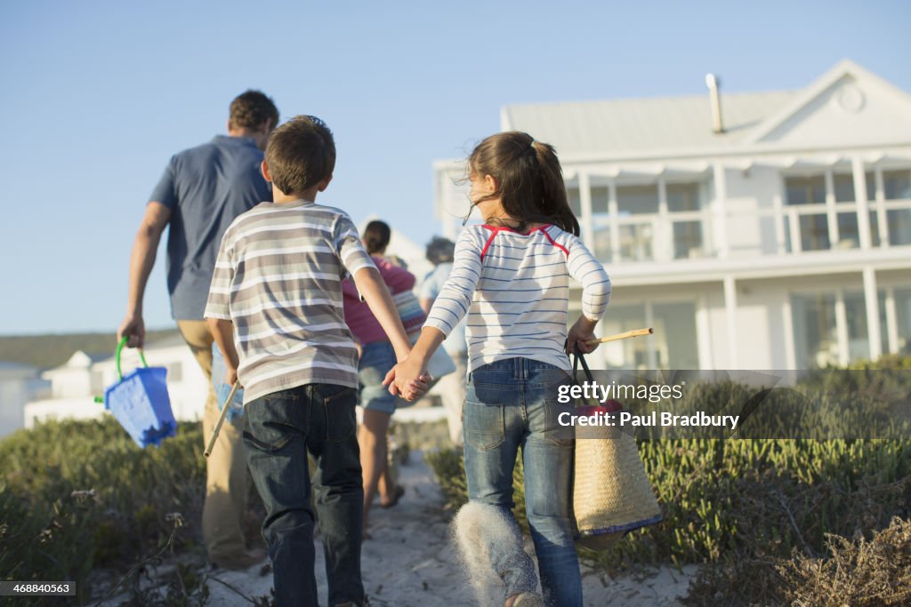 Brother and sister holding hands on beach path