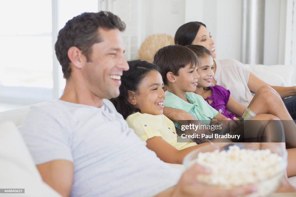 Family watching TV on sofa