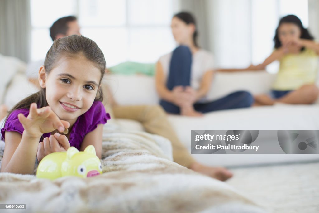 Girl putting coins in piggy bank