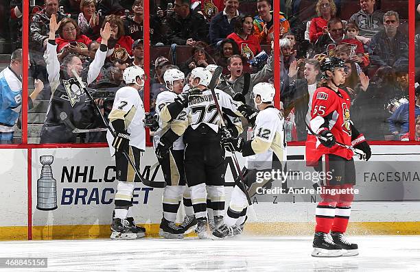 Sidney Crosby of the Pittsburgh Penguins celebrates his first period goal with teammates Paul Martin, Patric Hornqvist and Ben Lovejoy as Erik...