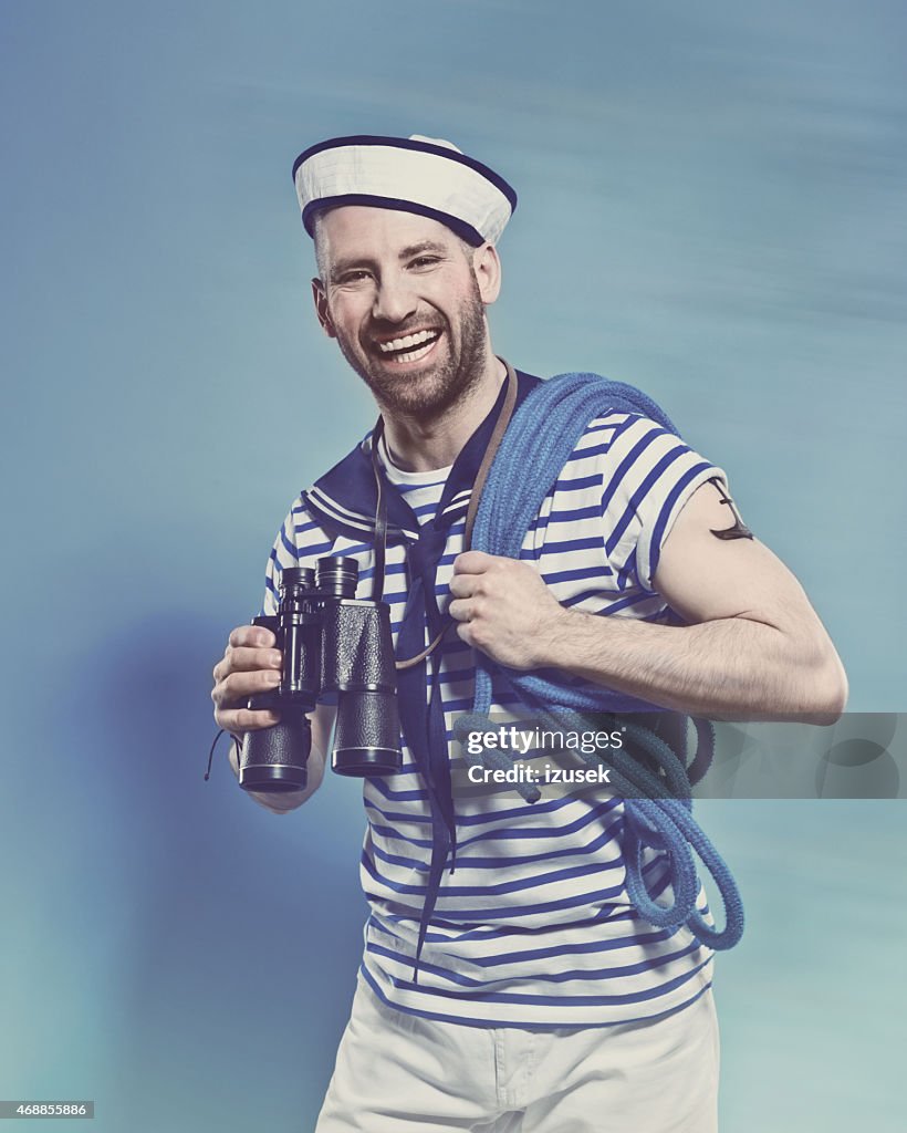 Bärtiger Mann in sailor-outfit holding Ferngläser