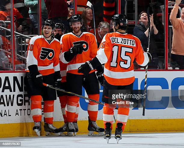 Brayden Schenn of the Philadelphia Flyers is congratulated by teammates Sean Couturier and Michael Del Zotto after Schenn scored the game winner with...