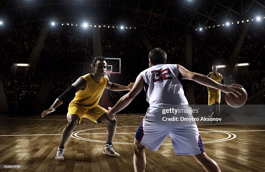 Two opposing basketball players facing each other