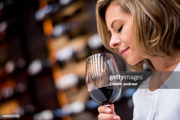 woman tasting wine at a cellar - sommelier stockfoto's en -beelden