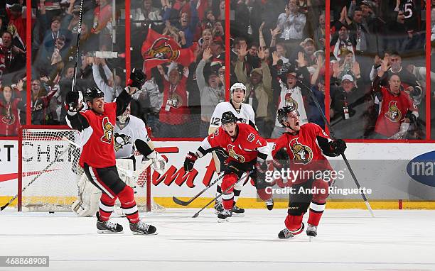 Mark Stone of the Ottawa Senators celebrates his overtime winning goal with teammates Marc Methot and Kyle Turris as Marc-Andre Fleury and Ben...