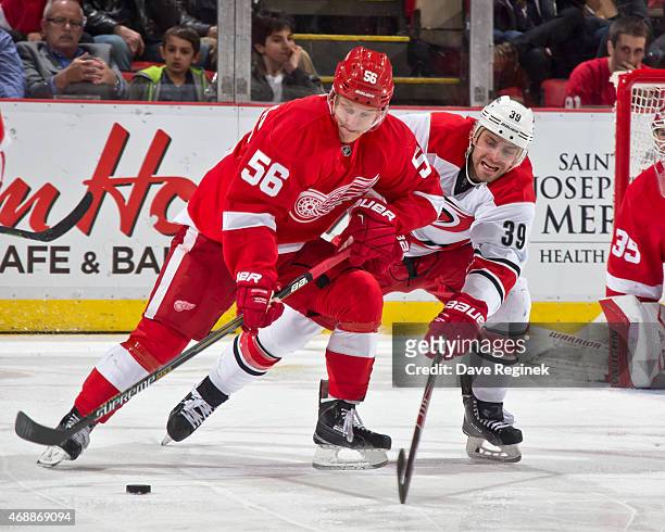 Teemu Pulkkinen of the Detroit Red Wings controls the puck as Patrick Dwyer of the Carolina Hurricanes pursues during a NHL game on April 7, 2015 at...