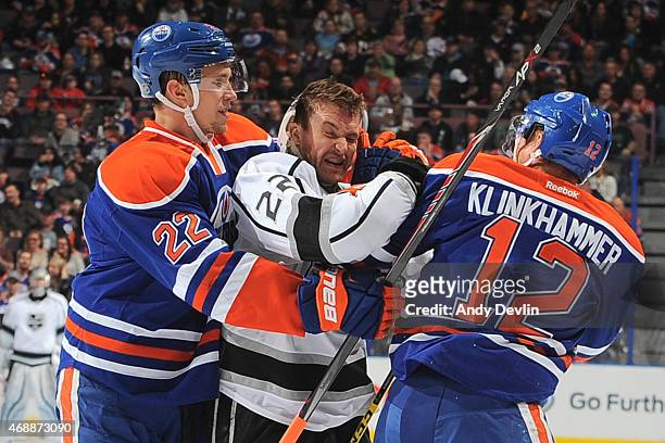 Rob Klinkhammer and Keith Aulie of the Edmonton Oilers scrum with Trevor Lewis of the Los Angeles Kings during the game on April 7, 2015 at Rexall...