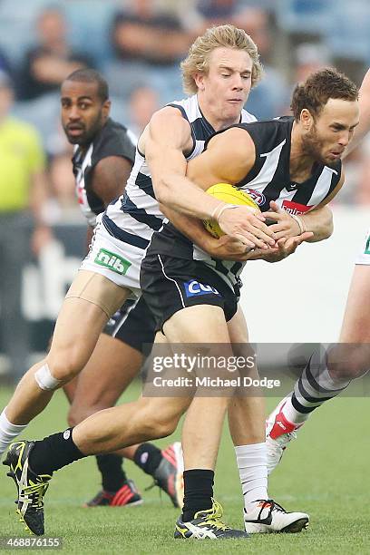 Brent Macaffer of the Magpies is tackled by Cameron Guthrie of the Cats during the round one AFL NAB Cup match between the Geelong Cats and the...