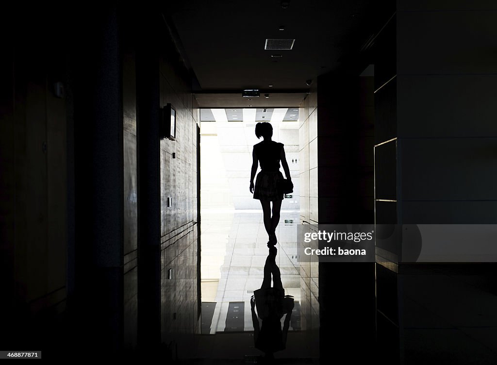 Woman walking into the light