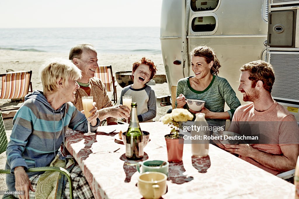 A family laughing together by the beach.