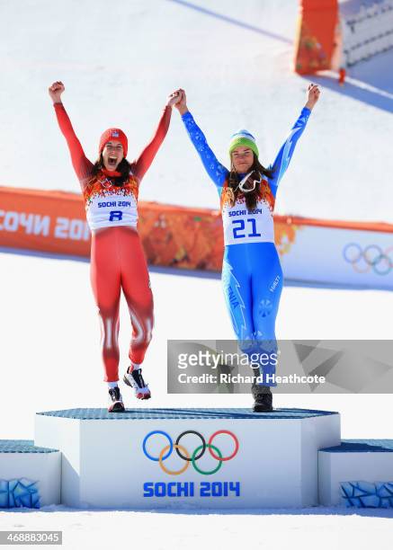 Gold medalists Dominique Gisin of Switzerland and Tina Maze of Slovenia celebrate on the podium during the flower ceremony for during the Alpine...