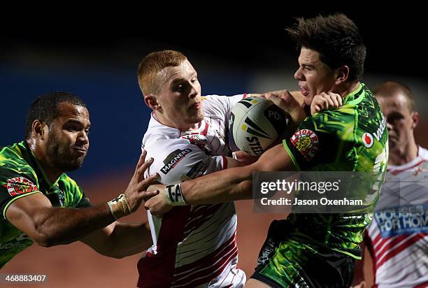 Jack Hughes of Wigan fends away Jarrod Wilson of the NZ Warriors in the NZ Warriors and Wigan rugby league match at Waikato Stadium on February 12,...