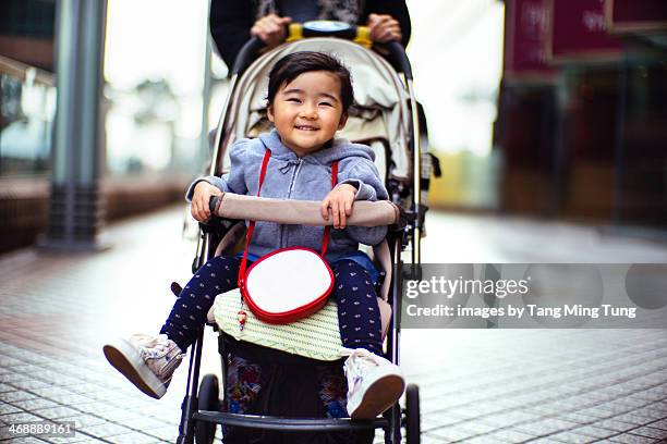 toddler girl smiling joyfully in the stroller - kinderwagen stockfoto's en -beelden